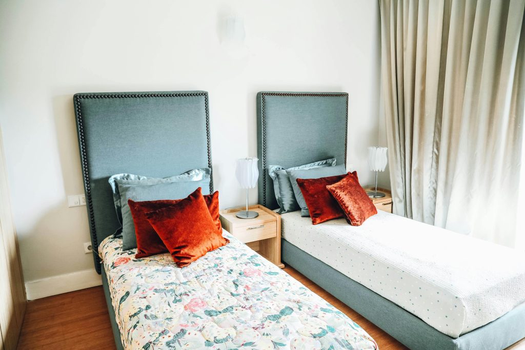Contemporary twin bedroom showcasing stylish decor and plush cushions for a cozy ambiance.